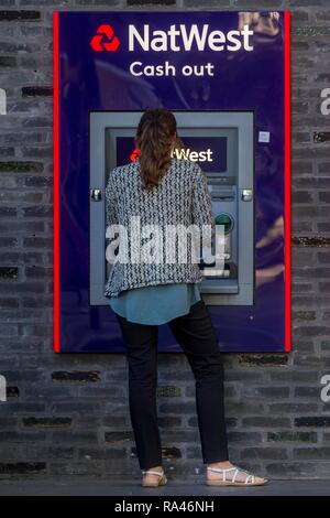 Donna al cash dispenser di Natwest Bank di Londra, Gran Bretagna Foto Stock