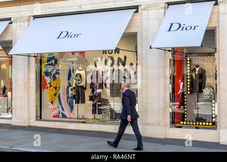 Passante nella parte anteriore del negozio finestra, fashion shop Dior, London, Regno Unito Foto Stock