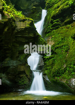 L'acqua scorre attraverso un foro nella roccia a St Nectan la cascata. Foto Stock