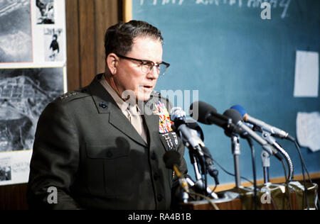 1975 - Comandante del Marine Corps generale Robert E. Cushman Jr. parla dopo touring alloggiamento temporaneo strutture erette per rifugiati vietnamiti. Foto Stock