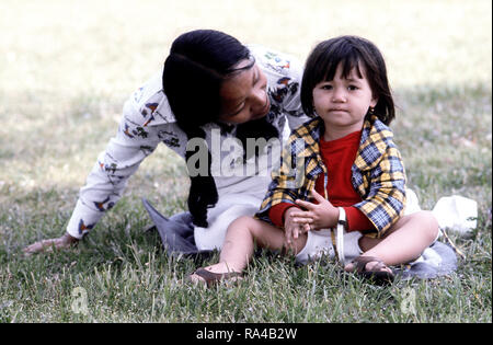 1975 - Una donna che gioca con un bambino in un alloggiamento temporaneo facility per rifugiati vietnamiti. Foto Stock