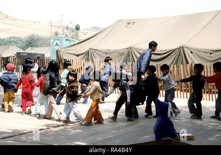 1975 - i bambini giocano a una temporanea struttura alloggiativa per rifugiati vietnamiti. Foto Stock