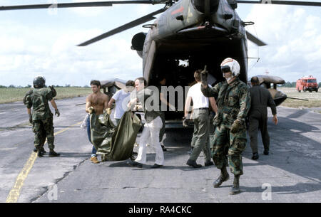 1978 - personale militare statunitense e i volontari di ripartire il carico di lavoro di resti di Jonestown vittime da un 55th Aerospace Rescue and Recovery Squadron HH-53 Jolly gigante verde elicottero. I corpi verranno messi in bare per il trasporto alla Dover Air Force Base, Delaware. Foto Stock