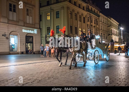 Un carro trainato da cavalli porta i turisti lungo le strade di Kraków-w, Piccola Polonia voivodato, Polonia. Foto Stock