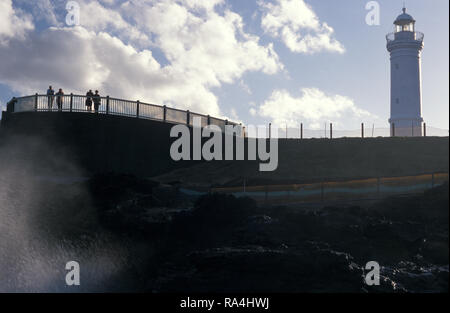 CIELO NUVOLOSO SUL KIAMA BLOWHOLE E LIGHTHOUSE, NUOVO GALLES DEL SUD, AUSTRALIA Foto Stock