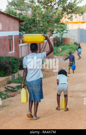 Donna che trasporta l'acqua a Entebbe, Uganda Foto Stock