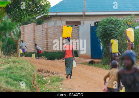 Donna che trasporta l'acqua a Entebbe, Uganda Foto Stock