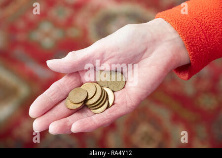 Anziani mano azienda denaro contante allentato cambiare monete pence rame risparmi pensionistici Foto Stock