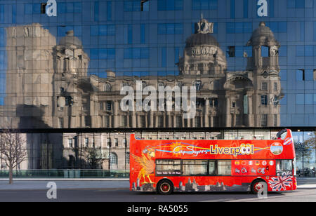 Gli autobus turistici oltrepassando l'isola di Mann Edificio, con scheda Dock edificio che rispecchia l'isola di Mann Edificio, Liverpool. Presa nel novembre 2018. Foto Stock