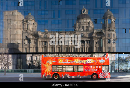 Gli autobus turistici oltrepassando l'isola di Mann Edificio, con scheda Dock edificio che rispecchia l'isola di Mann Edificio, Liverpool. Presa nel novembre 2018. Foto Stock