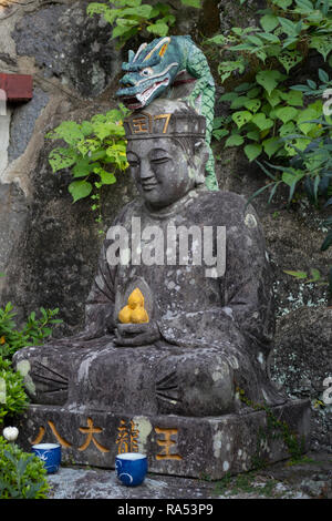 Nagasaki, Giappone - 24 Ottobre 2018: sorridente pietra antica statua del Buddha presso il tempio Kofukuji motivi Foto Stock