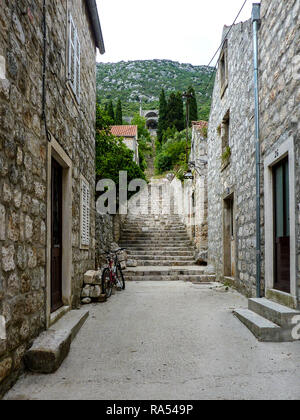 Passi che salgono attraverso il villaggio di Ston in Croazia con una vista delle pareti in corrispondenza della parte superiore Foto Stock