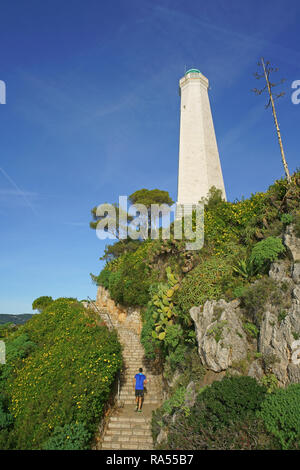 Runner di resistenza che corre su alcune scale all'aperto vicino ad un faro. Saint-Jean-Cap-Ferrat, Costa Azzurra, Alpi Marittime, Francia. Foto Stock
