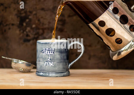 Versare il caffè nero in tazza Foto Stock