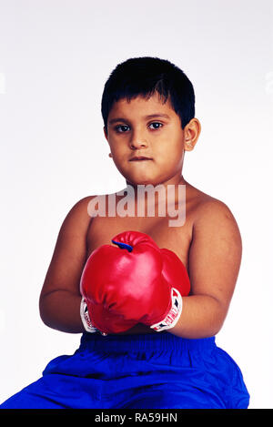 Ritratto di un giovane pugile con BOXIN GUANTI E sacco da boxe, sudorazione dopo una partita Foto Stock