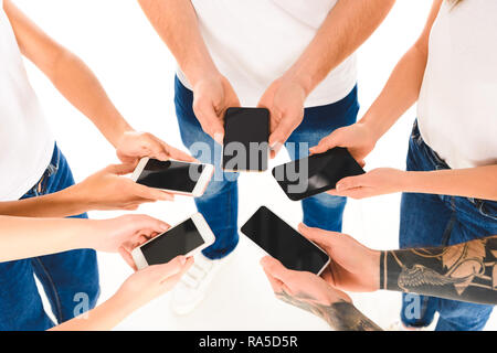 Vista ritagliata di un gruppo di persone in piedi in cerchio e tenendo gli smartphone con schermi vuoti in mani isolato su bianco Foto Stock