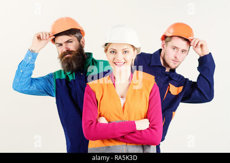 Il team di leadership e di concetto. Donna, leader in hard hat con la faccia felice sostare di fronte costruttori. Team di architetti, costruttori, operai spiata dietro al leader isolato sullo sfondo bianco. Foto Stock