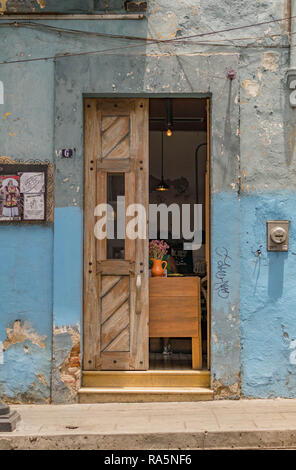 Cafe storefront, con blu e grigio grungy parete e di età compresa tra doppie porte in legno, Oaxaca, Messico Foto Stock