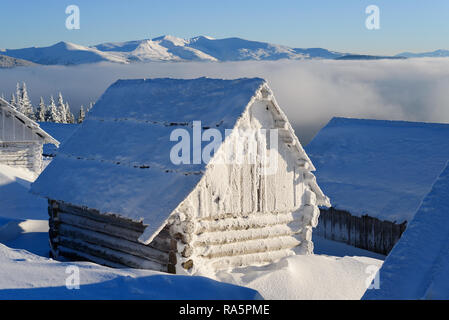 Paesaggio invernale con una baita di montagna. Casa in legno coperto di brina su un gelido inverno mattina Foto Stock