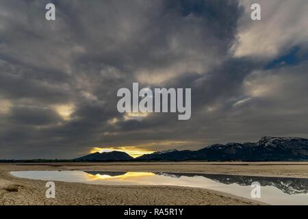 Incrinato, il terreno asciutto con acqua di superficie e delle Alpi di Allgäu in background, Forggensee, Füssen Ostallgäu, Baviera, Germania Foto Stock