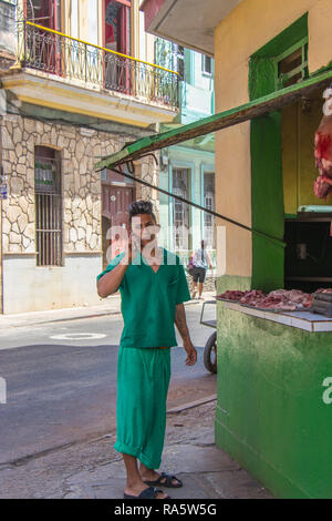 Il macellaio del giovane proprietario di una stalla fa una telefonata a l'Avana, Cuba, Caraibi Foto Stock