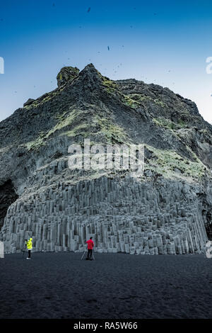 Fotografare la rupe di colonne di basalto lungo la Reynisfjara spiaggia di sabbia nera Islanda [Nessun modello di rilascio; disponibile per editoriale solo licenza] Foto Stock