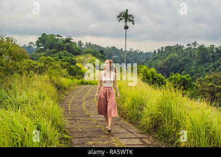 Giovane donna traveler in Campuhan Ridge a piedi , Scenic verde vallata di Ubud Bali Foto Stock