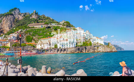 Signora rilassata che si immerga nella tranquilla vista di Almaafi sulla costa dell'Almaafi con i suoi picturreque, gli edifici colorati e il paesaggio aspro. Foto Stock