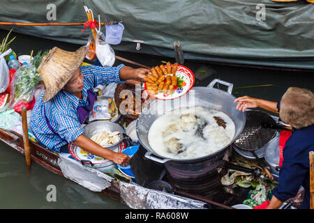 Damnoen Saduak - 4 Marzo 2014: Donne fornitori la frittura involtini primavera. La città è famosa per il suo mercato galleggiante. Foto Stock