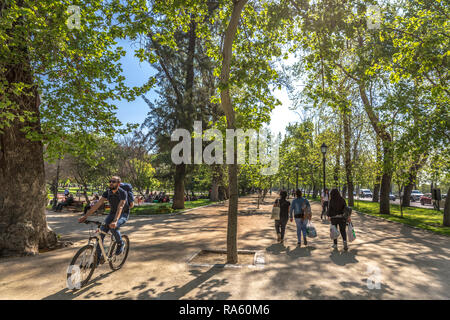 Santiago del Cile - 1° OTT 2017 - Un ragazzo in una bicicletta e un gruppo di persone che camminano in un open air parco pubblico di Santiago del Cile, capitale del Cile Foto Stock