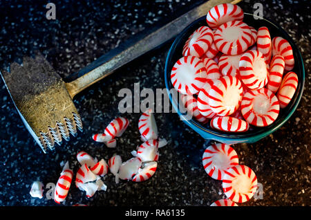 La menta piperita candy è schiacciato con un vintage tenerizzatore mazzuolo in preparazione per rendere la corteccia di menta piperita, Dic 31, 2018 in Coden, Alabama. Foto Stock