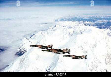 1978 - un'aria-aria - Vista laterale sinistra di quattro F-4E Phantom II aeromobili in formazione sul Monte McKinley. Gli aerei sono assegnati per il XXI Tactical Fighter Wing, Elmendorf Air Force Base in Alaska. Foto Stock