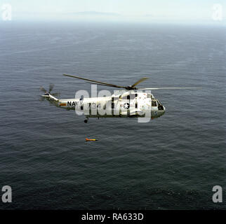 1976 - un'aria-aria - Vista laterale destra di un elicottero anti-sommergibile Squadron 6 (HS-6) SH-3 Sea King elicottero con ASQ-81 la rivelazione di anomalie magnetiche (MAD) ingranaggio sospesi al di sotto di esso durante le azioni di formazione al largo della costa della California del Sud. Foto Stock
