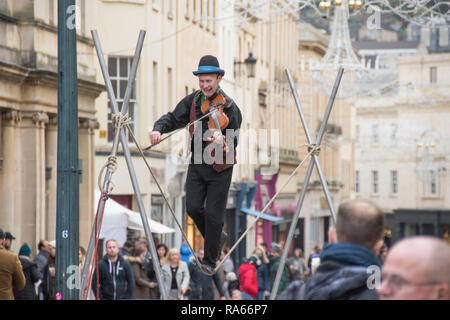 Bath, Regno Unito. Il 1° gennaio 2019. Un animatore di strada svolge il suo violino mentre si cammina su una fune nel centro di Bath, Inghilterra sul primo giorno del 2019 come la folla degli acquirenti fanno la maggior parte del giorno di nuovi anni di vendite. Credito: Phil Rees/Alamy Live News Foto Stock