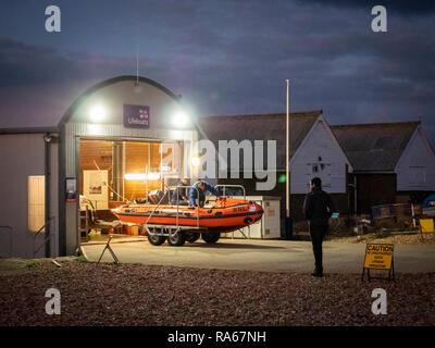 Eastbourne, East Sussex, Regno Unito, 1 gennaio 2019. Il RNLI scialuppa di salvataggio è lanciato dalla spiaggia sulla costa sud appena come esso diventa scuro sulla costa sud stazione balneare. L'equipaggio spinto la classe D scialuppa di salvataggio costiera lungo la spiaggia di ciottoli con un piccolo trattore e sped fuori nelle tenebre. Credito: Julian Eales/Alamy Live News Foto Stock