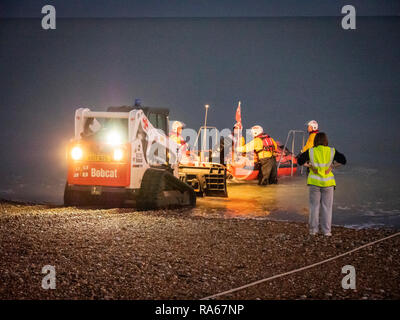 Eastbourne, East Sussex, Regno Unito, 1 gennaio 2019. Il RNLI scialuppa di salvataggio è lanciato dalla spiaggia sulla costa sud appena come esso diventa scuro sulla costa sud stazione balneare. L'equipaggio spinto la classe D scialuppa di salvataggio costiera lungo la spiaggia di ciottoli con un piccolo trattore e sped fuori nelle tenebre. Credito: Julian Eales/Alamy Live News Foto Stock