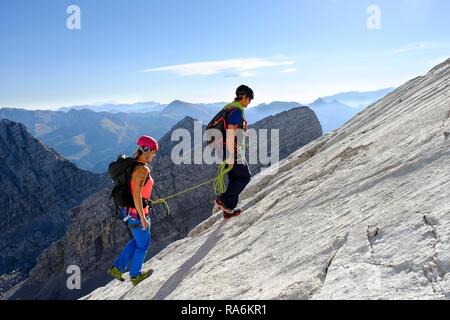 Guida di montagna la guida di una giovane donna su un breve corda attraverso una parete di roccia, Wiederroute, Watzmann, Schönau am Königssee Foto Stock