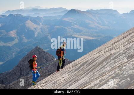Guida di montagna la guida di una giovane donna su un breve corda attraverso una parete di roccia, Wiederroute, Watzmann, Schönau am Königssee Foto Stock