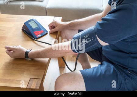 La misurazione della pressione sanguigna in modo automatico la parte superiore del braccio monitor della pressione del sangue, Germania Foto Stock