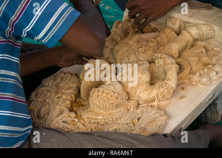 Una stone mason scalpelli i tocchi di rifinitura per i suoi religiosi indù stone carving. Foto Stock