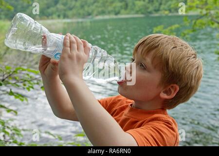 Ragazzo beve l'acqua da una bottiglia di plastica, il Parco Nazionale dei Laghi di Plitvice, Croazia Foto Stock
