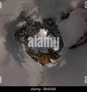 Panorama casa chalet durante una nevicata nel gli alberi della foresta di inverno di notte al chiaro di luna. Minuscolo pianeta 360 panorama Foto Stock