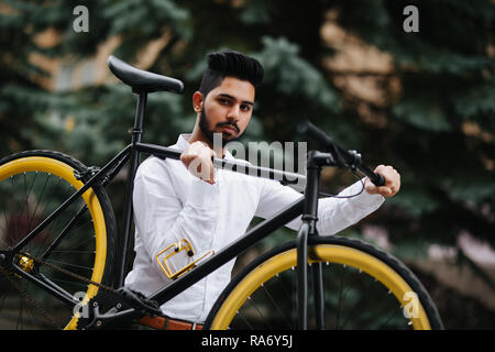 Razza mista hipster uomo che porta bicicletta sulla spalla in città Foto Stock