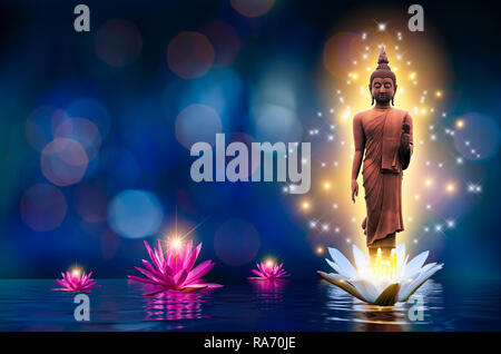 La statua del Buddha sorge su un bianco e rosa lotus nell'acqua. Bokeh sfondo blu. Foto Stock