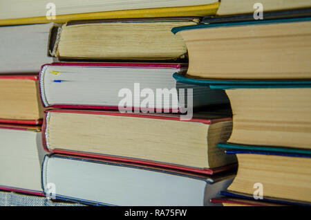 Una pila di coloratissimi libri sullo scaffale di una libreria o di una stanza di close-up Foto Stock