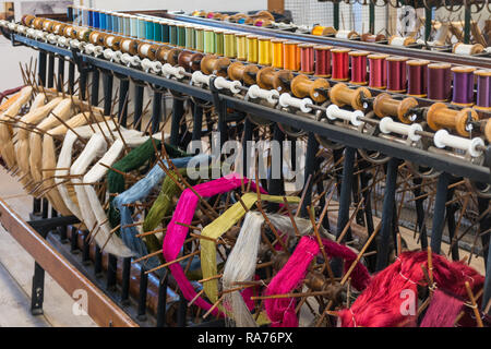 Whitchurch Setificio in Hampshire, Regno Unito. Interno del museo con seta colorata filati avvolti in rocche o in bobine. Foto Stock