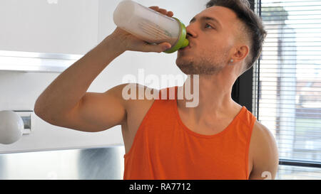 Giovane uomo bere un frullato o bere un frullato di proteine Foto Stock