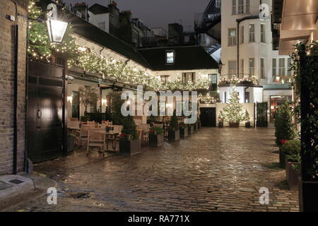 Le luci di Natale sulla sfera blu cortile con area frontale di American Bar. Fine domenica sera nessun popolo nel bar la strada sembra vuota. Foto Stock