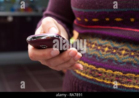 Donna che utilizza il telefono cellulare, metà sezione Foto Stock