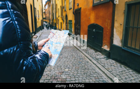 Lo stile di vita di viaggio. Donna traveler con la mappa in mano per le strade di Stoccolma Foto Stock